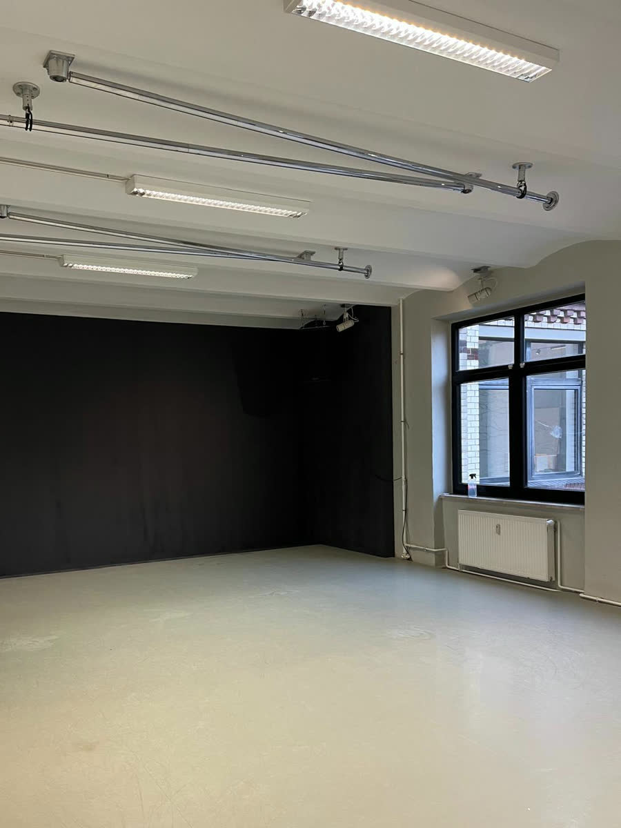 Raum mit einer tiefmatten, schwarz gestrichenen Wand aus Lehmfarbe, die das Licht vollständig schluckt